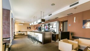 Eine Hotelhalle mit Barbereich, Sitzgelegenheiten und einer Rezeption.