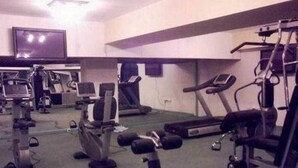 Une salle de sport équipée de divers appareils d’exercice, notamment des tapis de course, un vélo d’appartement et des appareils de musculation.