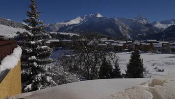A snow-covered mountain landscape with a village and buildings in the foreground.