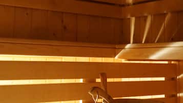 L’intérieur d’une cabane en bois, avec un banc et un seau en bois.