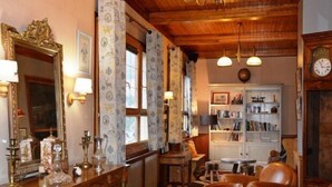 Comedor tradicional con una mesa de madera, sillas, una estantería y un espejo grande.