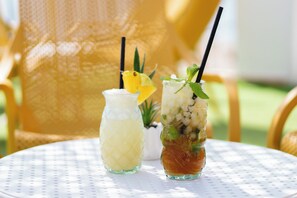 Dos bebidas sobre una mesa blanca con superficie texturizada.
