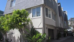 A two-story house with a garage, a tree, and a driveway.