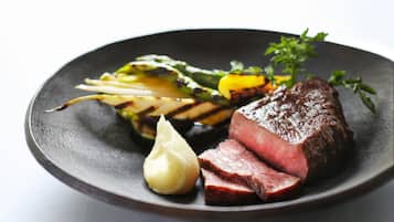 A plate with steak, grilled vegetables, and a dollop of sauce.