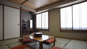 A traditional Japanese room with tatami flooring, a low wooden table, and sliding doors. - Hotel New Nishino (Kagoshima)