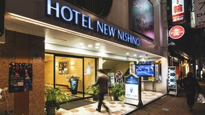 The exterior of Hotel New Nishino with a clear entrance, potted plants, and a visible signboard. - Hotel New Nishino (Kagoshima)