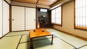 A traditional Japanese room with tatami flooring, a low wooden table, sliding doors, and a window with shoji screens. - Hotel New Nishino (Kagoshima)