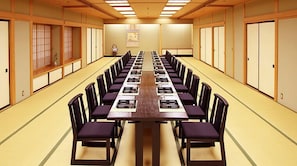 Ein Konferenzraum mit einem langen Tisch, Stühlen und traditionellen japanischen Schiebetüren.