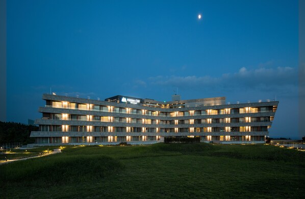 Un hotel de varios pisos con un diseño moderno, que presenta un techo plano y un llamativo letrero que dice 'Hidden City'.