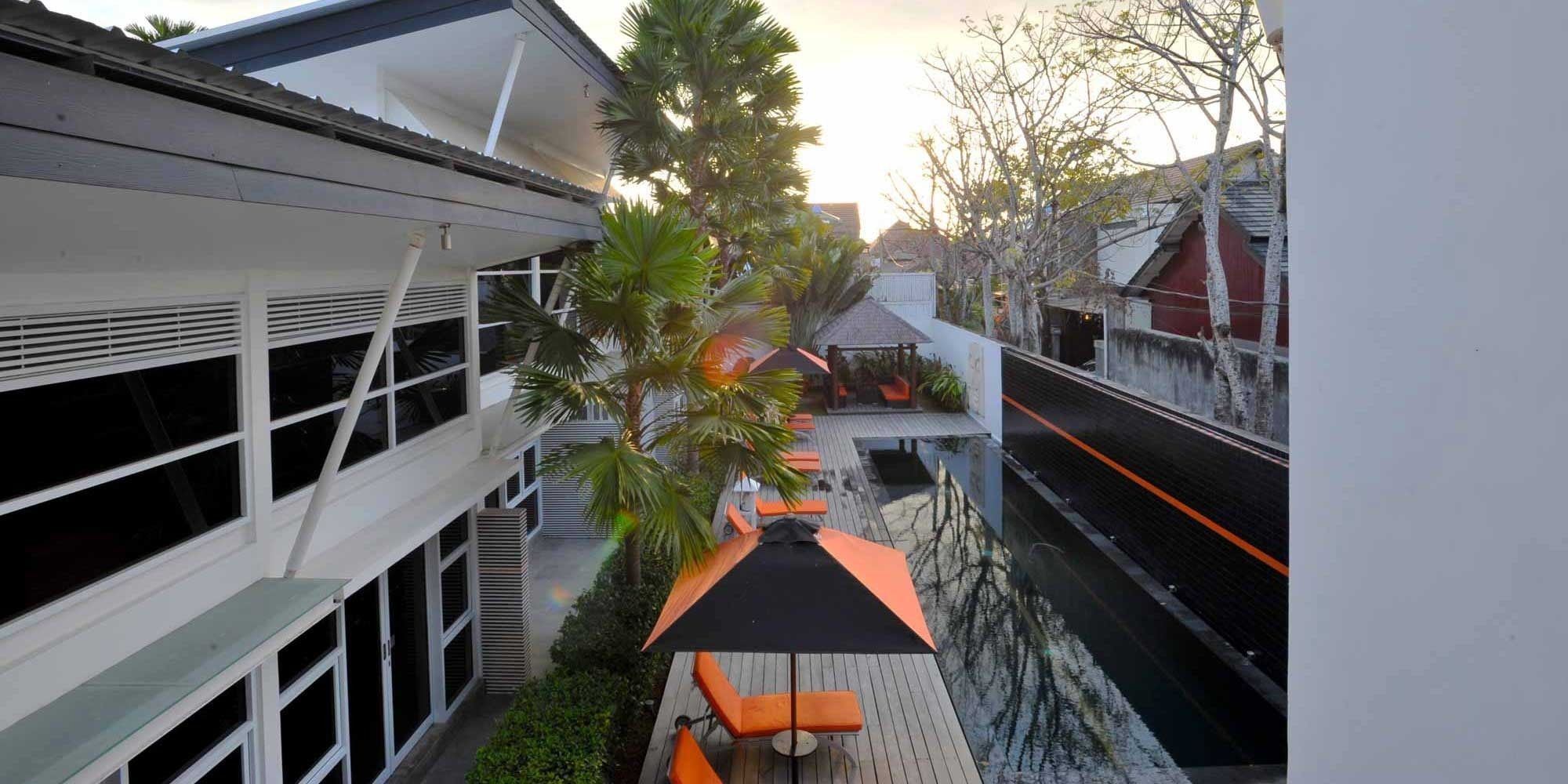 A modern building with a rooftop deck, outdoor seating, and a view of the surrounding area.
