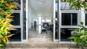A modern interior with a central seating area, large windows, and a ceiling fan. - Bali Yarra Villas Seminyak (Seminyak)