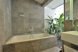 A modern bathroom with a freestanding bathtub, a sink, and a mirror. - Bali Yarra Villas Seminyak (Seminyak)