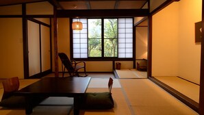 A traditional Japanese room with tatami flooring, a low table, and a window with shoji screens. - Yojokan Haru no Hikari (Hakone)