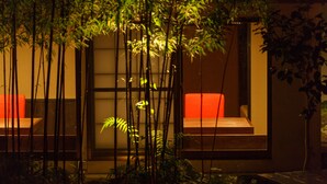 A modern building with a glass facade, a red sofa, and bamboo plants. - Yojokan Haru no Hikari (Hakone)