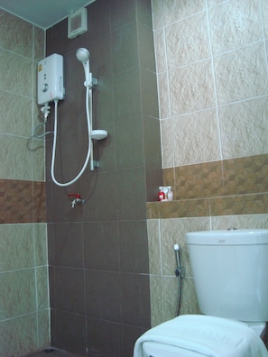 A bathroom with a shower, toilet, and a towel rack.
