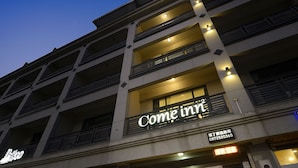 Un hotel de varios pisos con balcones y un letrero que dice 'Come inn'.