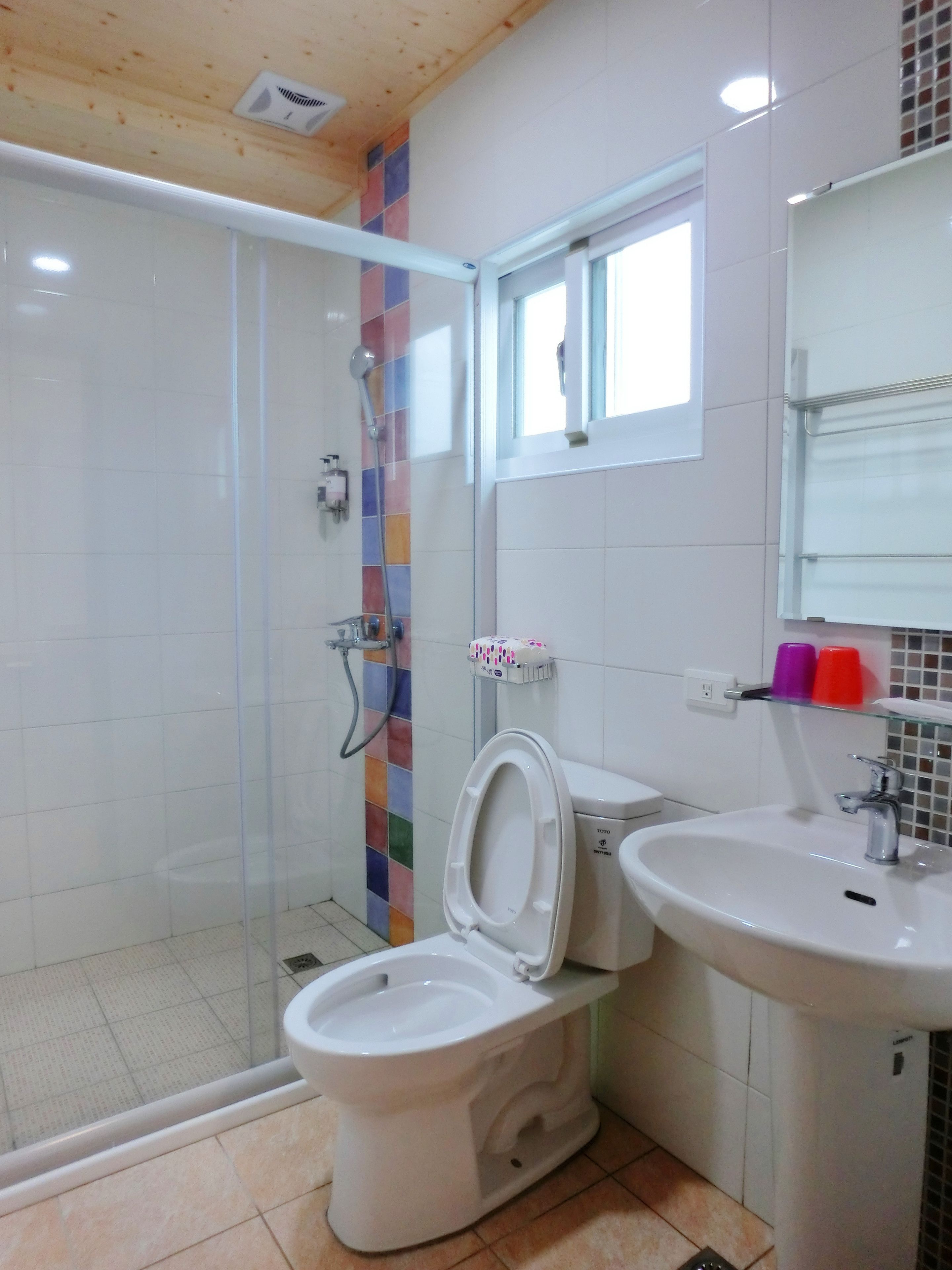 A bathroom with a shower, toilet, and sink.
