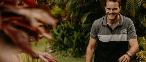 A man and a child walking on a stone pathway surrounded by greenery.