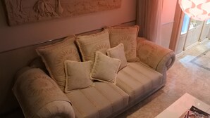 A beige sofa with patterned cushions in a room with a marble floor and a large wall-mounted sculpture. - HOTEL DRESSY -Adults Only (Himeji)