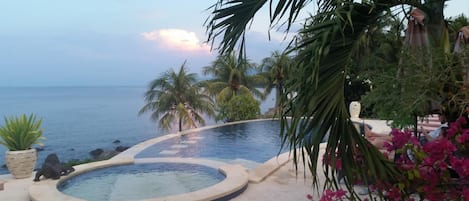 Una piscina al aire libre, sombrillas, tumbonas