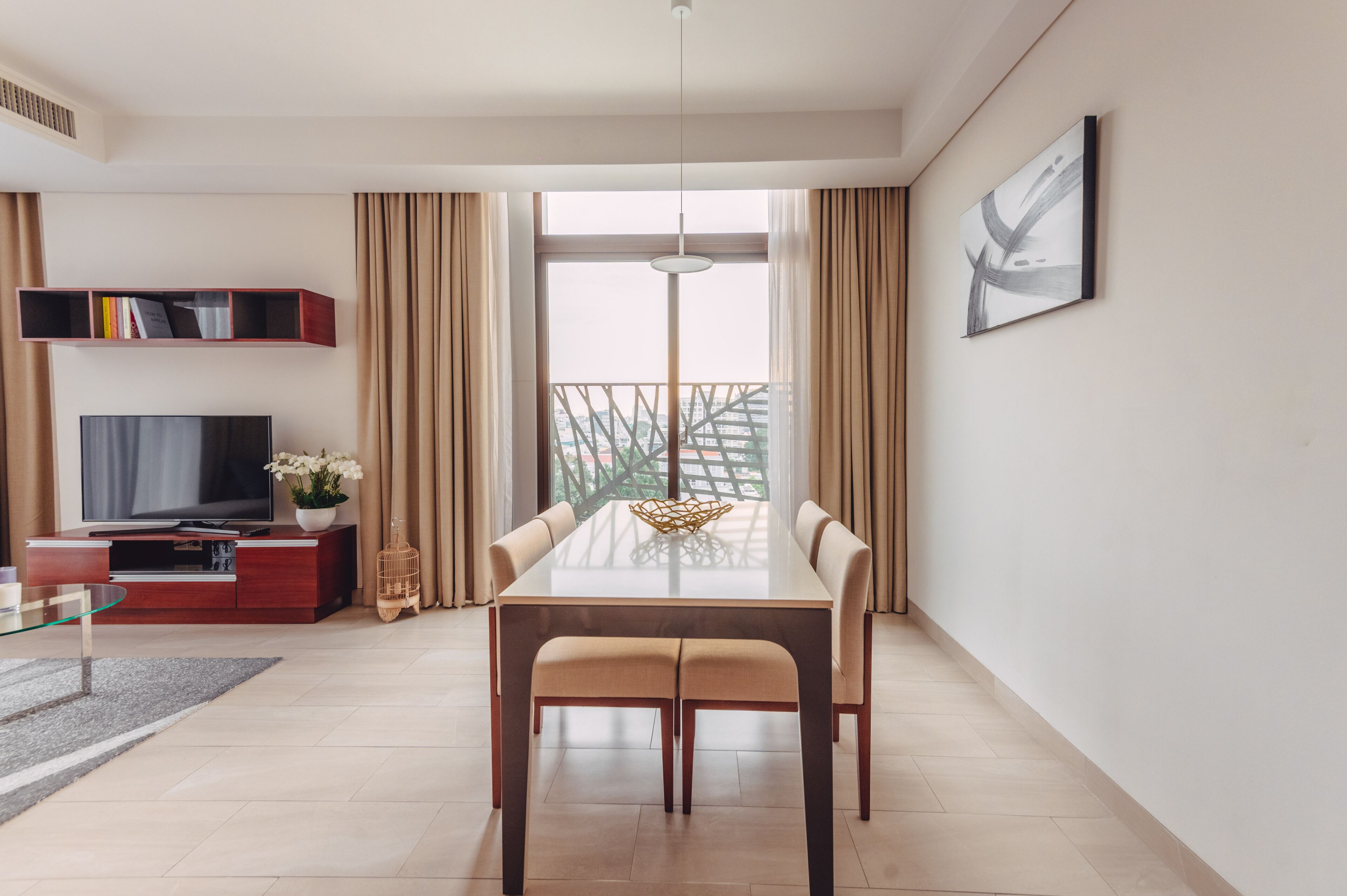 A modern living room with a dining area, a TV, and a balcony with a view.