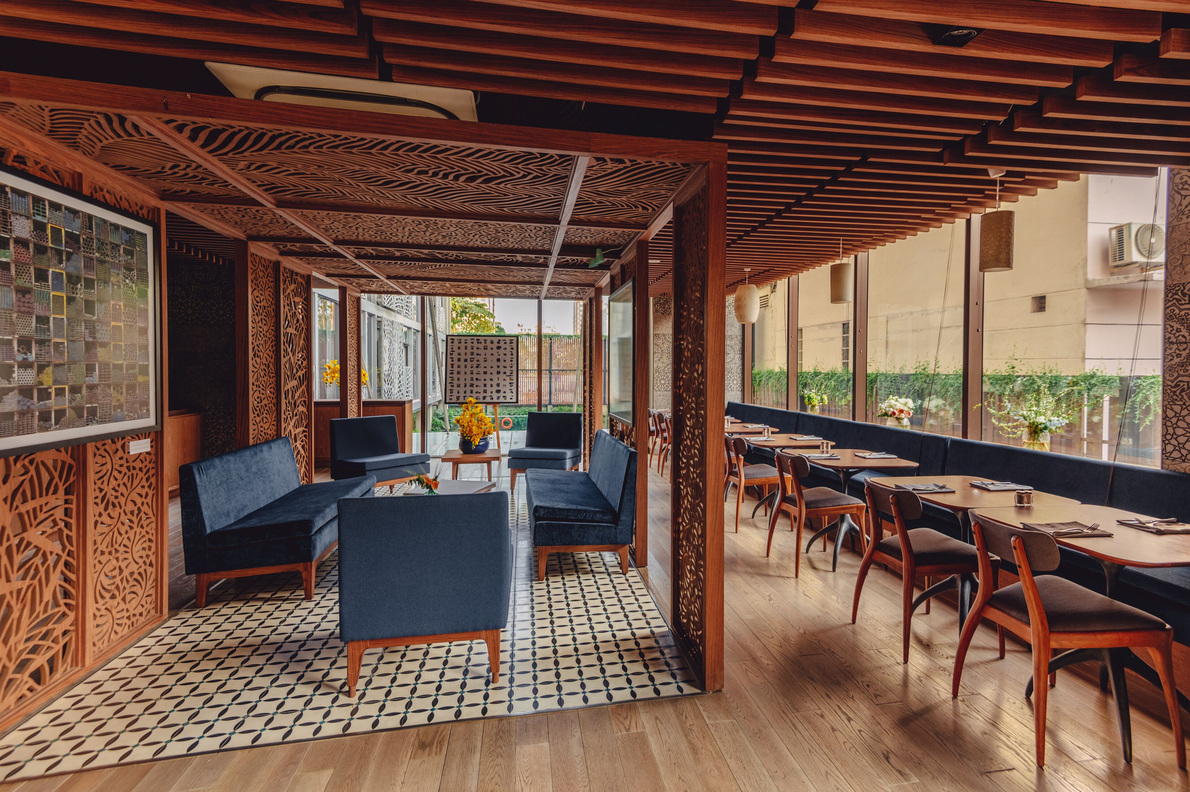 A restaurant with wooden ceiling panels, blue seating, and a tiled floor.