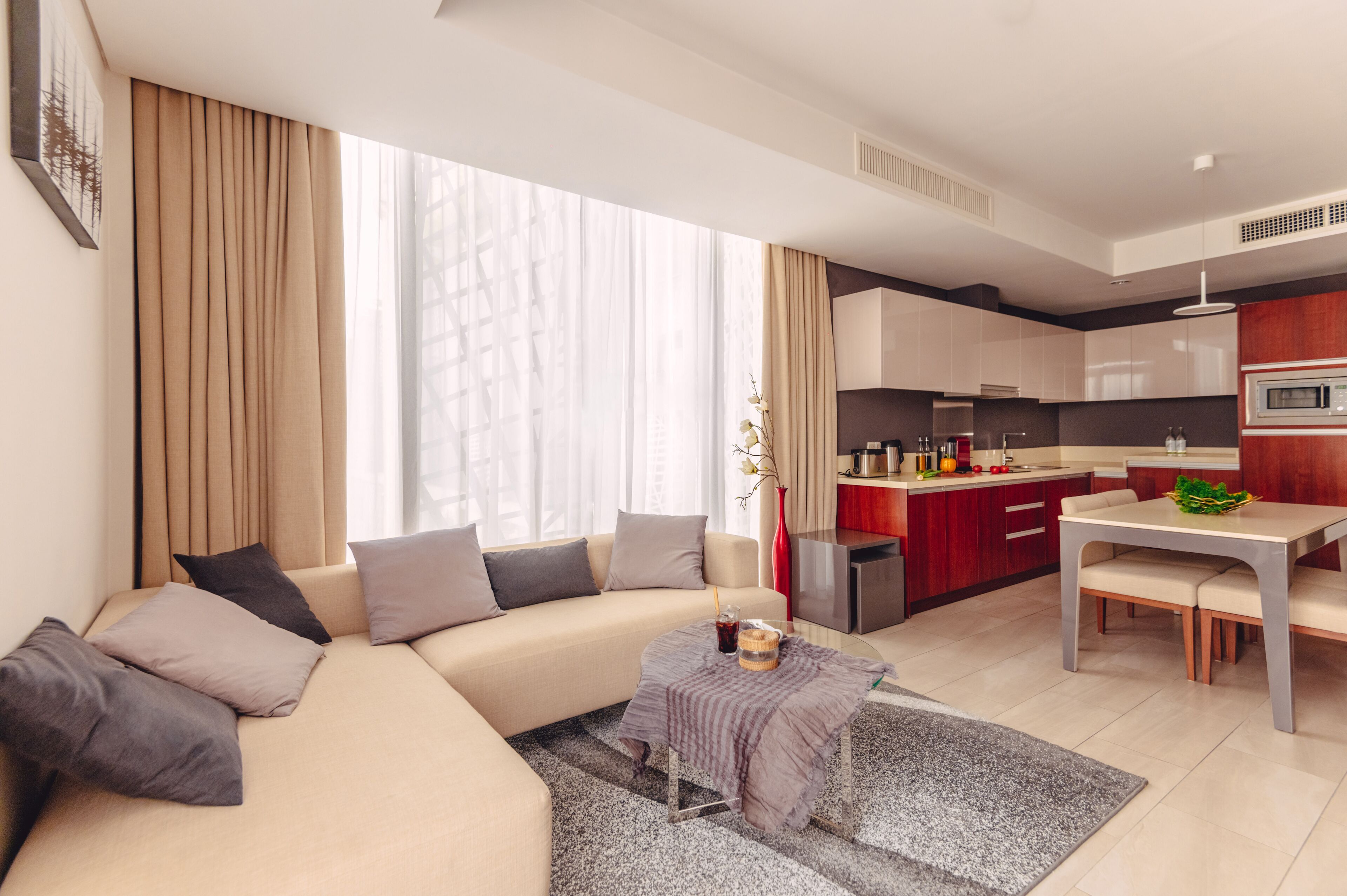A modern living room with a sofa, a coffee table, and a dining area with a table and chairs.