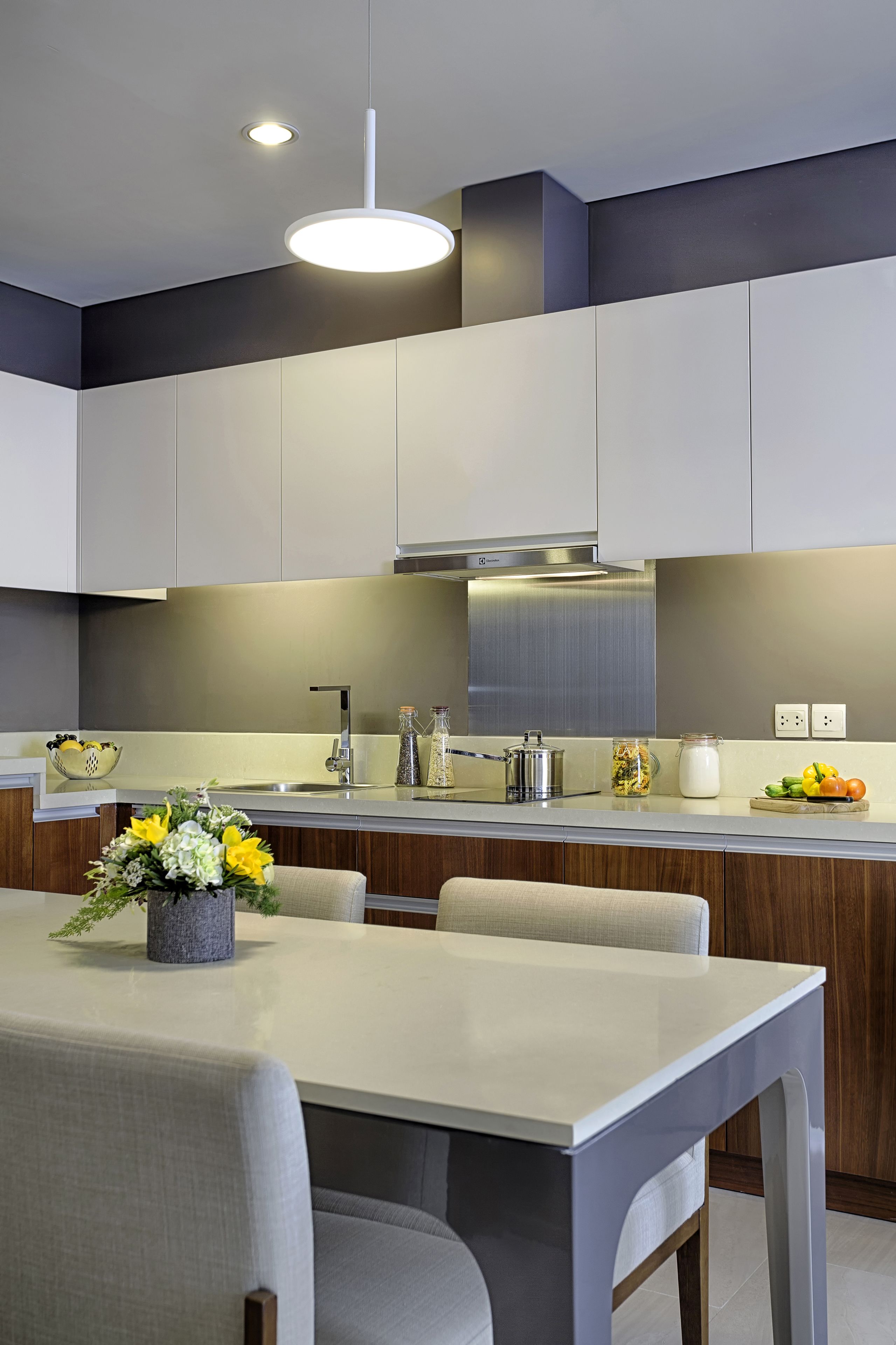 Een moderne keuken met een centraal eiland, roestvrijstalen apparatuur en een neutraal kleurenpalet.