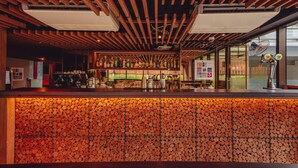 A bar area with a wooden ceiling and a wall of stacked logs. - SILA Urban Living (Ho Chi Minh City)