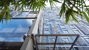 A modern building with a glass facade and metal lattice windows. - SILA Urban Living (Ho Chi Minh City)