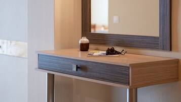 A bathroom vanity with a mirror, a small cabinet, and a stool.