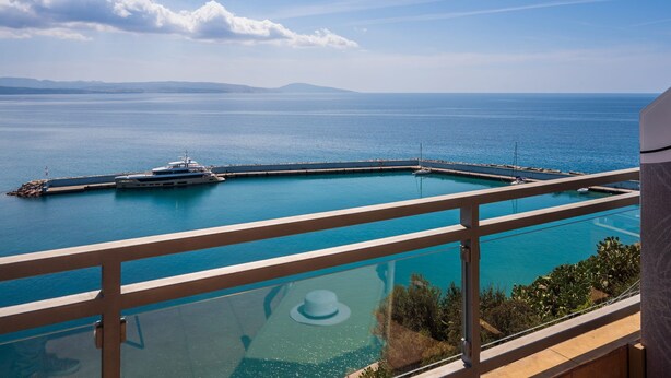 A balcony with a view of a marina and the sea. - Minos Boutique Hotel Agia Galini (Agios Vasileios)