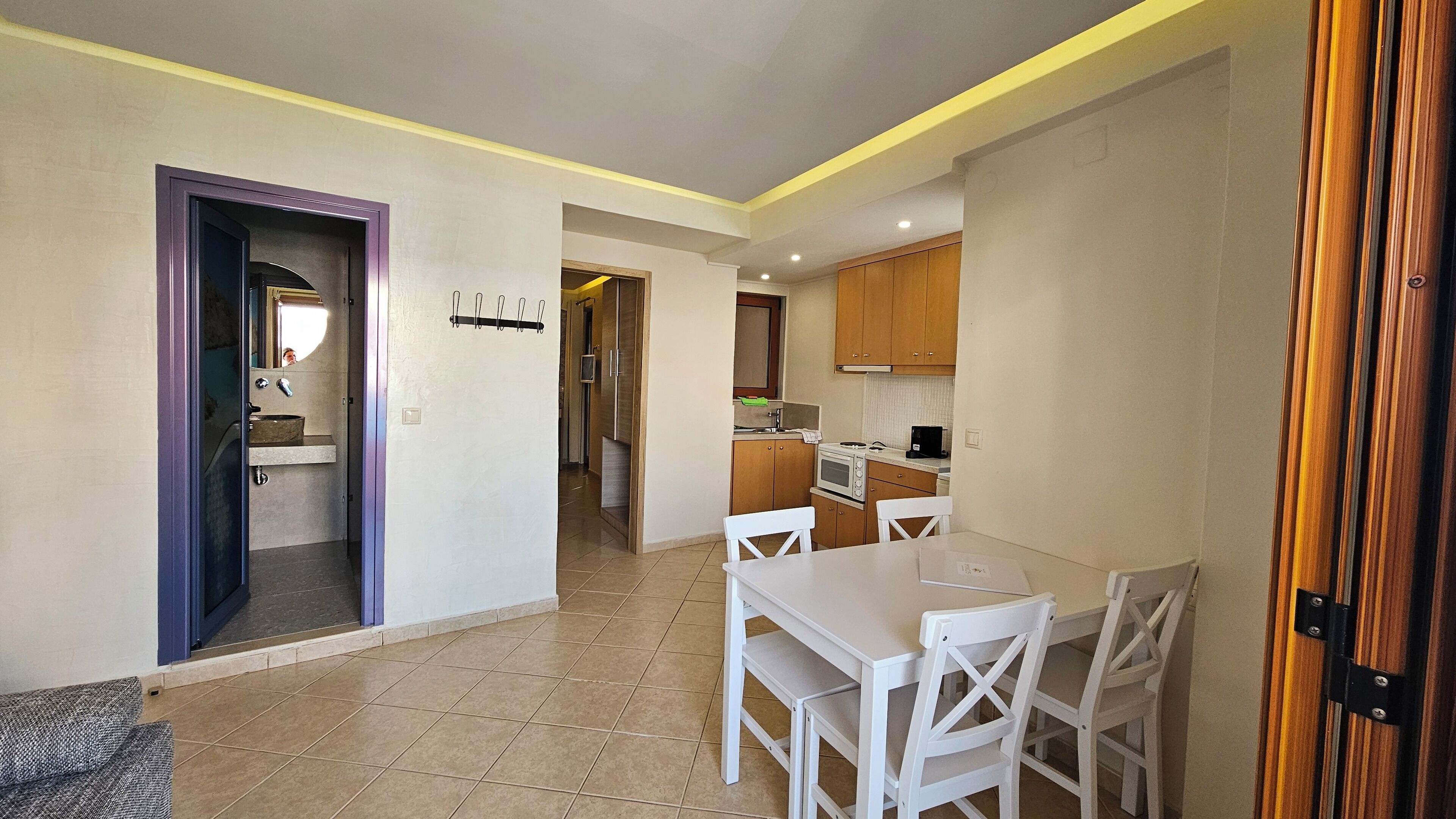 A compact kitchen with a dining area, a visible sink, and a microwave.