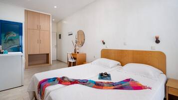 Un dormitorio con cama, cómoda, espejo y escritorio.