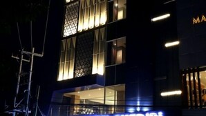 A modern building with illuminated windows and a visible entrance. - Citihub Hotel @Kediri (Kediri)