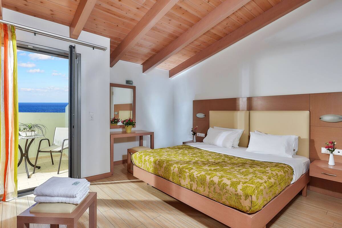A bedroom with a bed, bedside table, and a desk with a chair.