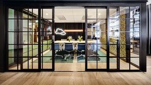 A modern office space with a meeting room, glass partitions, and a decorative light fixture. - Generator Stockholm (Stockholm)