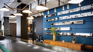 A modern reception area with a long counter, pendant lighting, and a wall with motivational quotes. - Generator Stockholm (Stockholm)