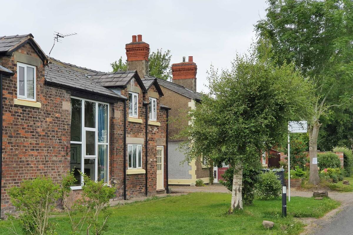 A row of brick houses with a well-maintained lawn and a clear road.
