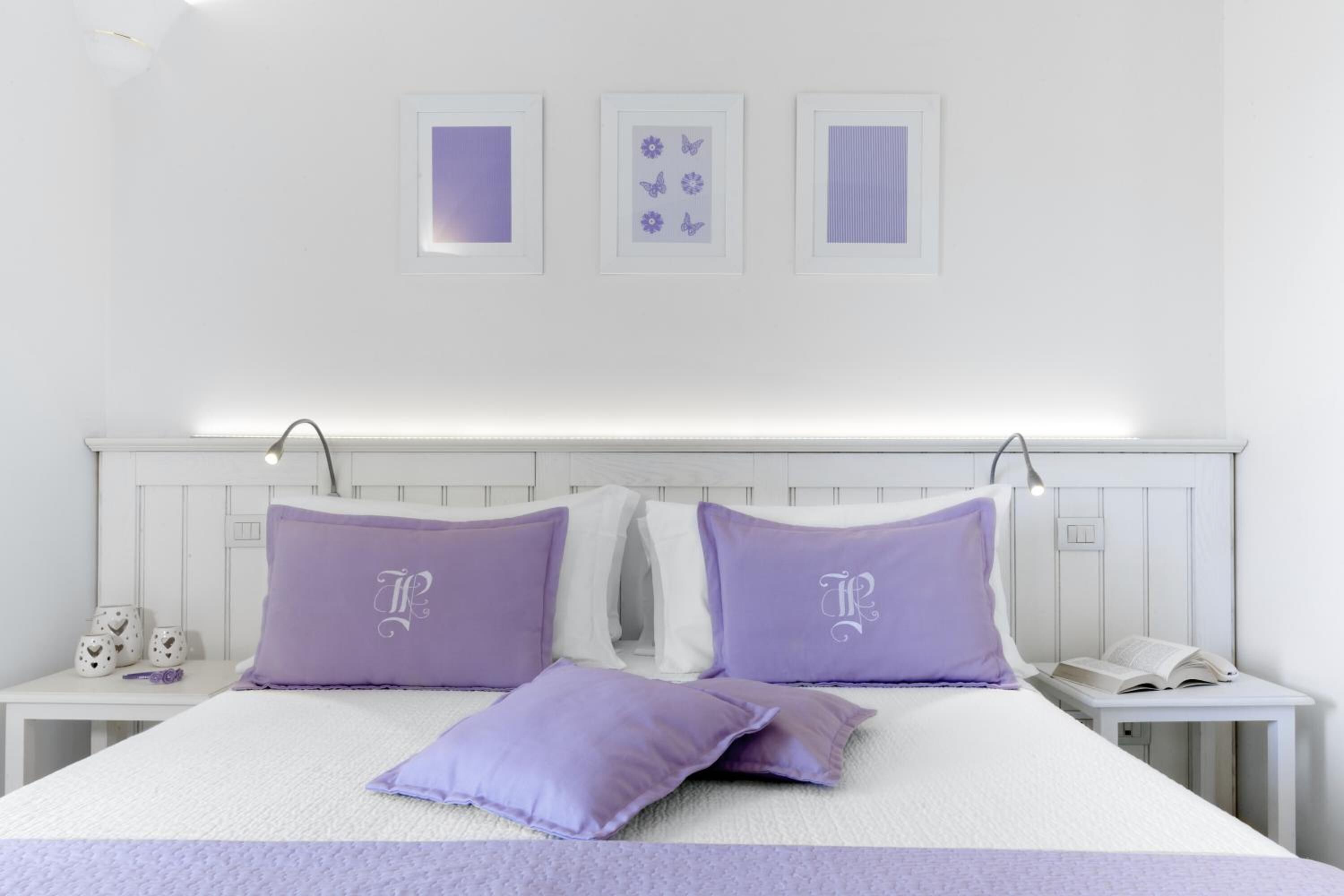 Ein ordentlich eingerichtetes Schlafzimmer mit einem Bett, zwei Nachttischen und einem kleinen Tisch.