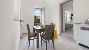 Un espace repas comprenant une table, des chaises et donnant sur l’extérieur.
