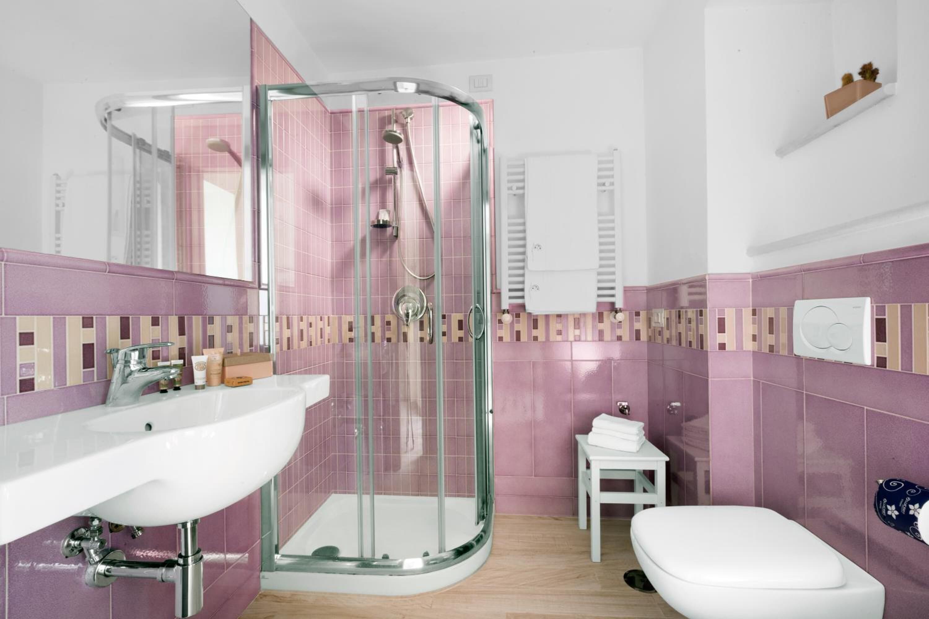 A modern bathroom with a glass-enclosed shower, a white sink, and a toilet.