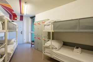 A dormitory room with bunk beds, a door, and a set of lockers. - Hostal Ganbara (Bilbao)