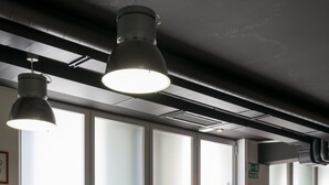 A modern interior with large windows, multiple tables, and pendant lighting. - Hostal Ganbara (Bilbao)