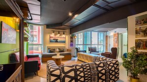 A modern interior with a sofa, a coffee table, and a bookshelf. - Hostal Ganbara (Bilbao)