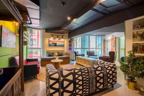 A modern interior with a sofa, a coffee table, and a bookshelf. - Hostal Ganbara (Bilbao)