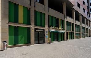 A building with a green and yellow facade, a sign reading 'GANBARA HOSTEL,' and a wheelchair-accessible entrance. - Hostal Ganbara (Bilbao)