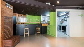 Una cocina moderna con detalles de madera, una pared de acento verde y vistas al área de comedor.
