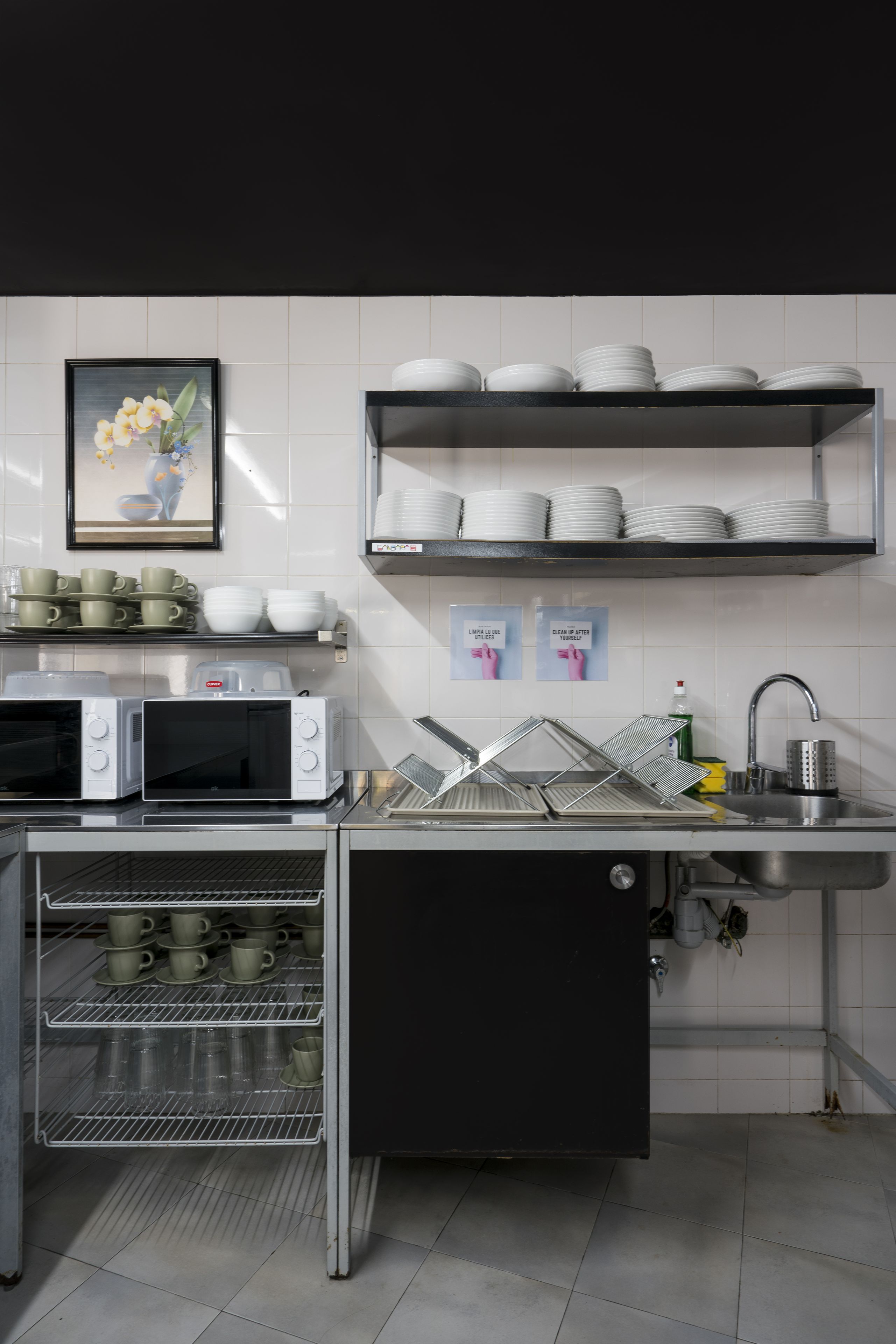 Una cocina con microondas, horno, fregadero y escurreplatos.