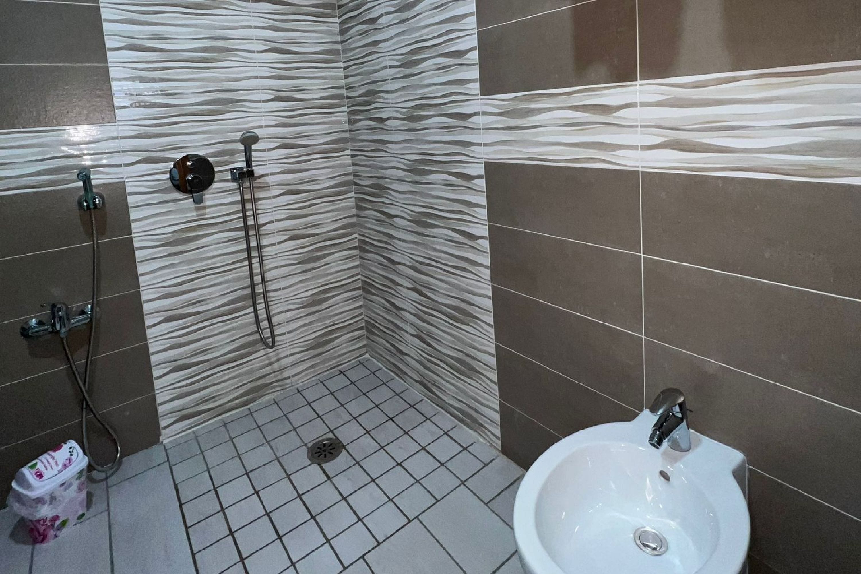 A bathroom with a shower, a sink, and a toilet.